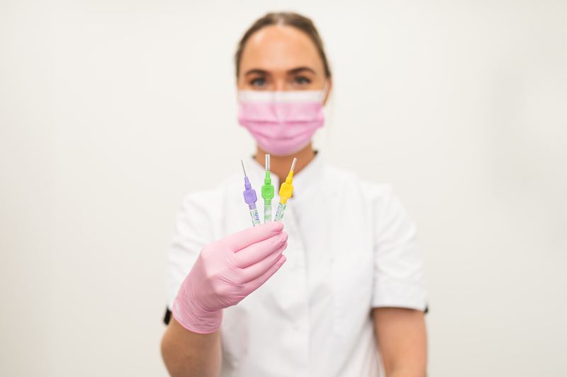 Mondhygiënist houdt drie ragers in verschillende maten omhoog