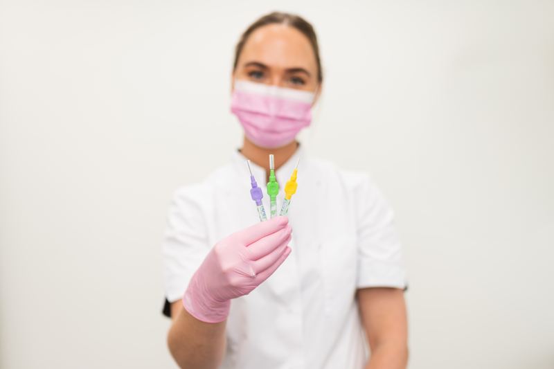 Mondhygiënist laat drie ragers zien voor het reinigen tussen de tanden